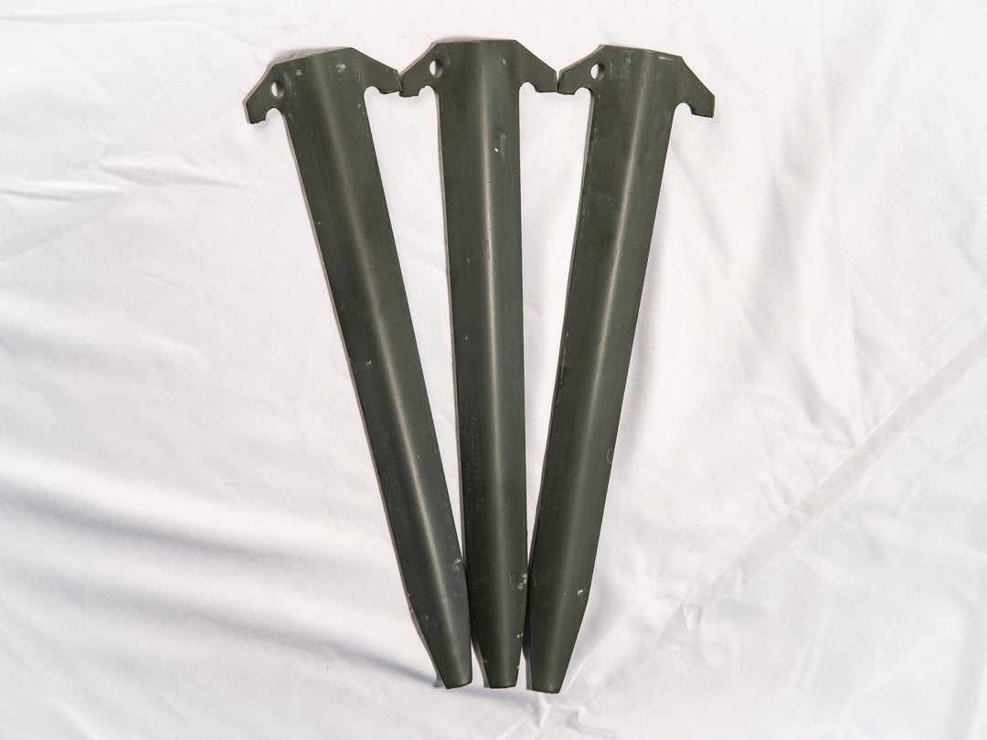 Three aluminum tent stakes on a white background
