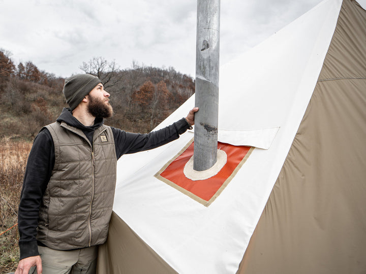 Man adjusting a tent in a natural setting 
