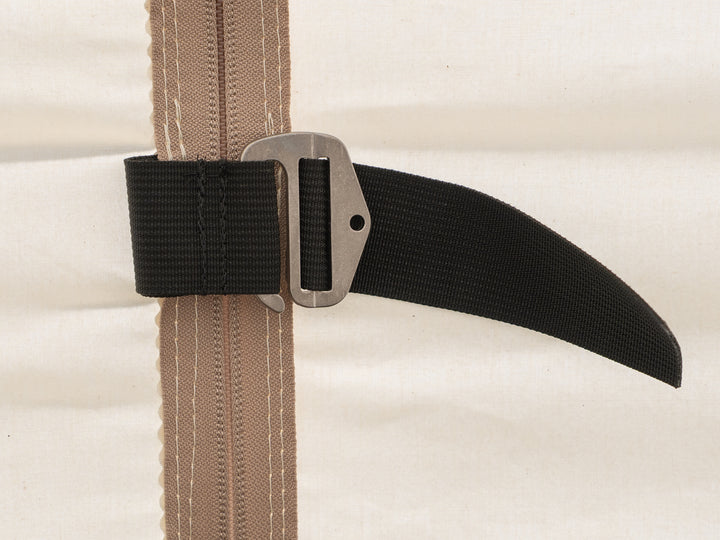 Close-up of a black webbing belt with a metal g hook tent door closure