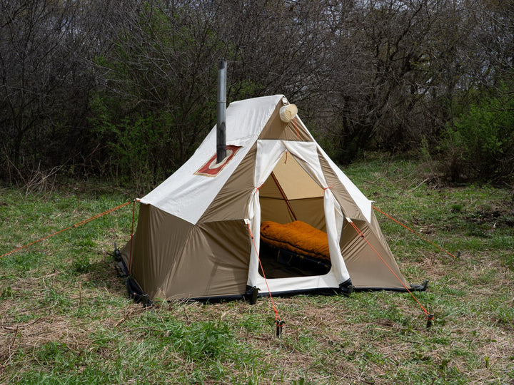 Beige camping tent with in a grassy outdoor setting