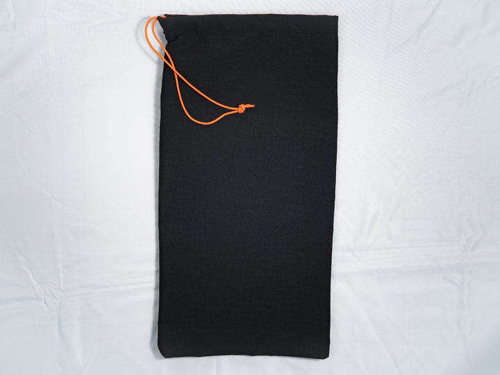 Black drawstring bag with orange drawstring on a white background