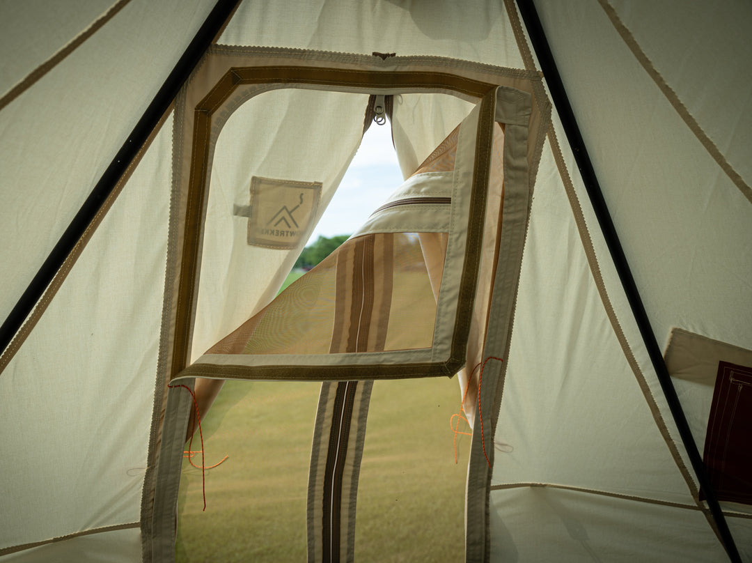 Snowtrekker 11x11 high country inside tent looking out through screen door with top left corner folded to the right showing velcro attachment of the screen door to the inside door frame of the tent