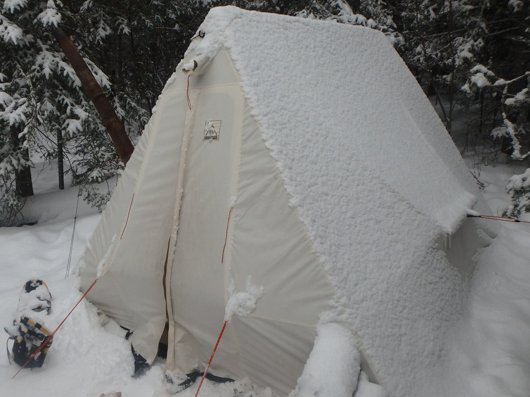 Snowtrekker 9x11.5 Crew With Snow On Tent snowshoes left of the door with pine trees in background