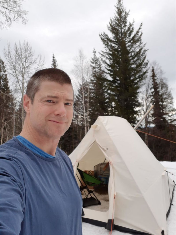 Rob with his Snowtrekker Tent set up in the snow near trees