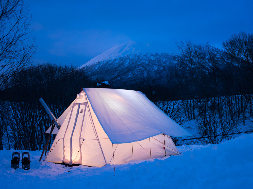 Snowtrekker 10x13 Outfitter setup in snow wit Tent Fly trees and snow covered mountain in background