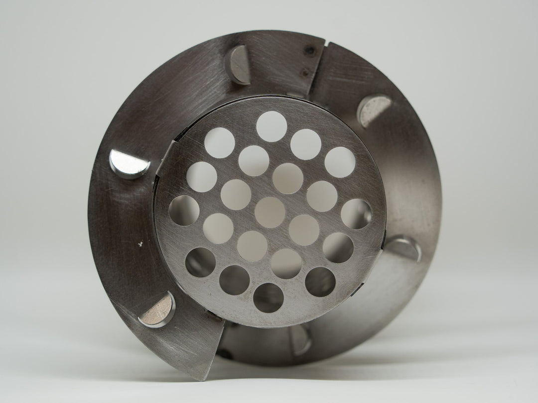 Metallic component with circular design and multiple holes on a white background