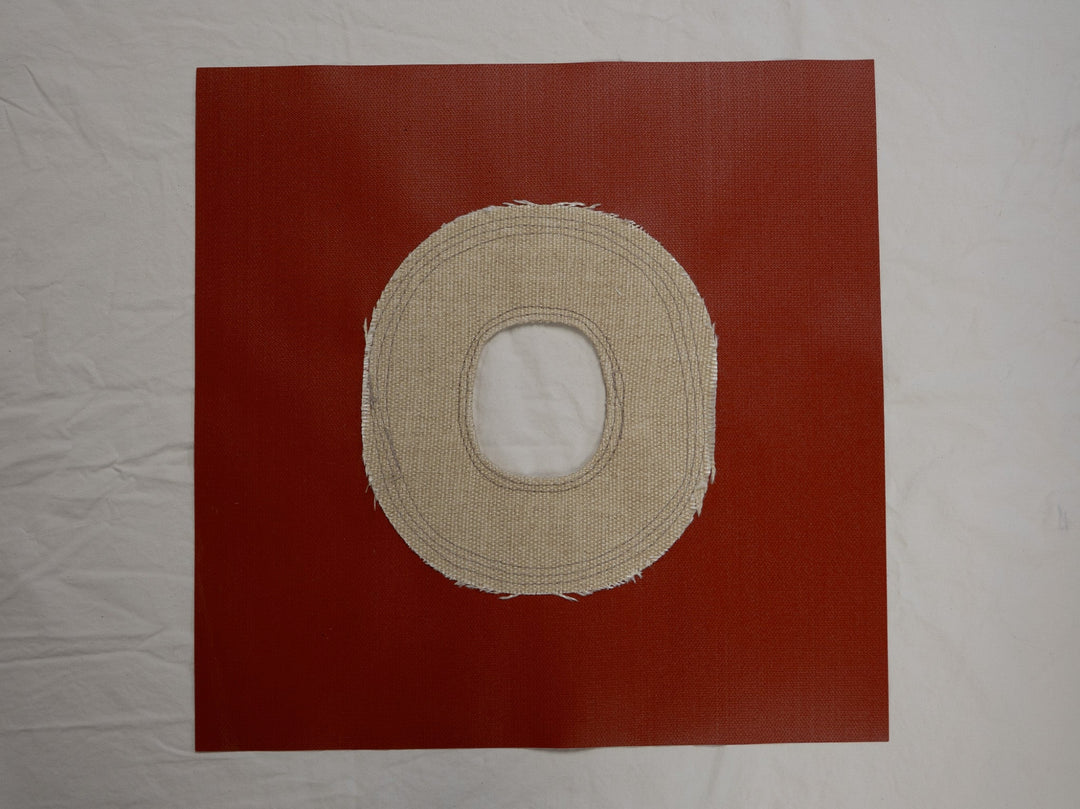 Beige circular fabric sample on a red background