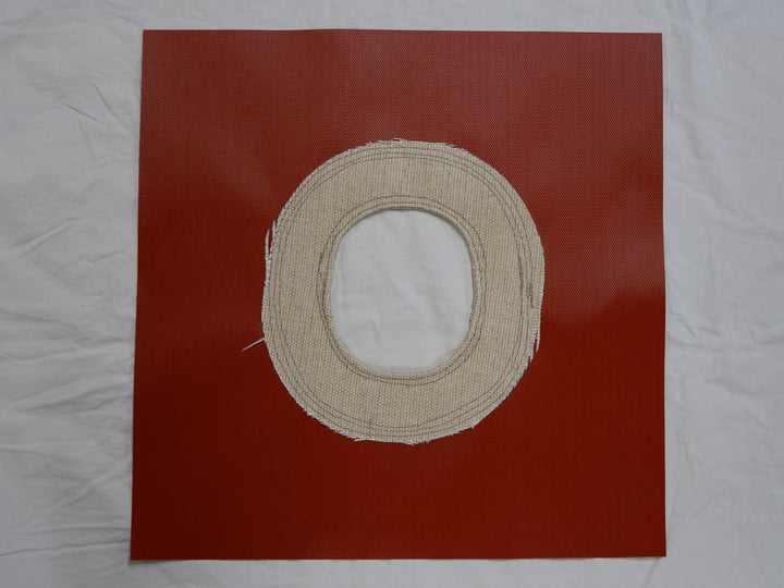 Beige circular fabric patch on a red square background