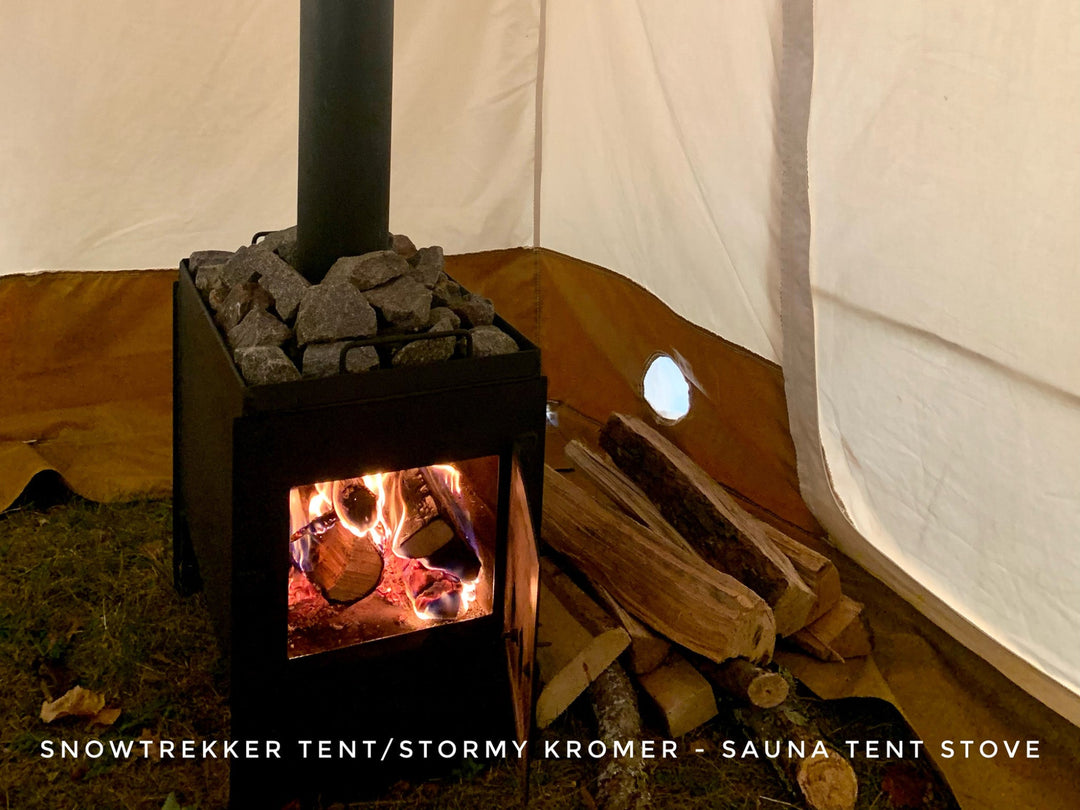 Sauna tent stove inside a snowtrekker tent with visible flames and wood.