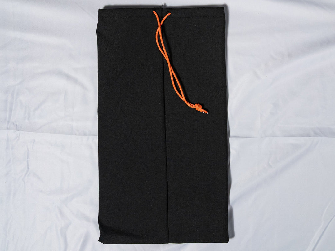 Black drawstring bag with an orange drawstring on a white background