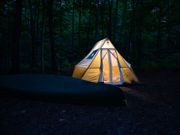 Lit tent in a dark forest