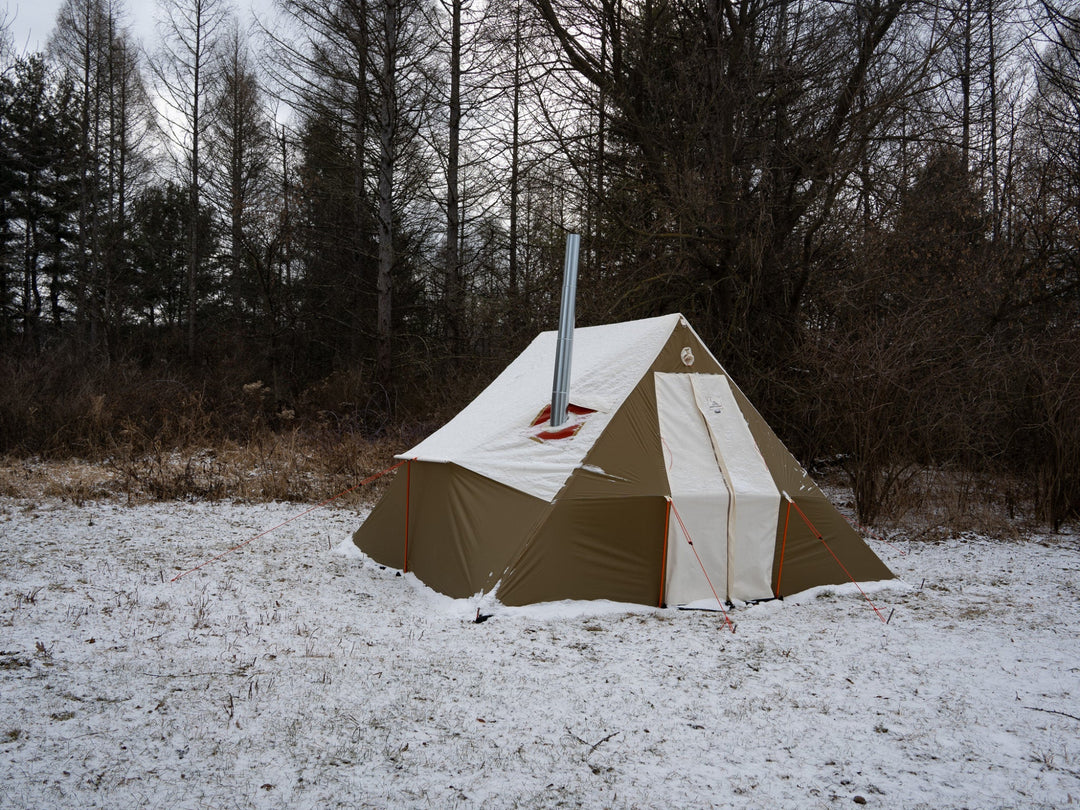 Tent with a chimney in a snowy forest