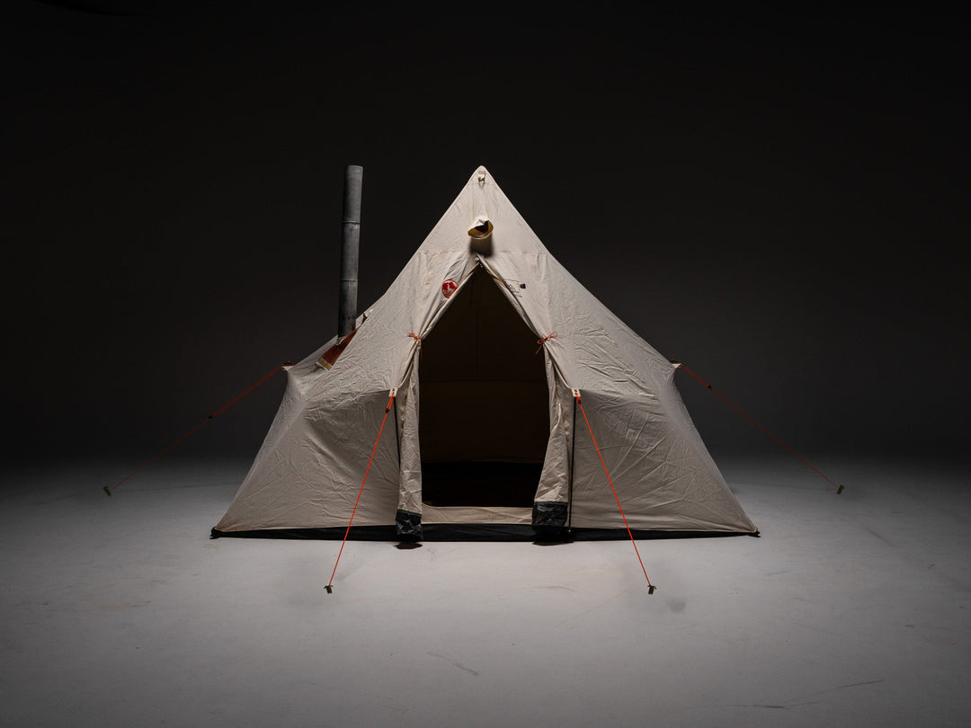 Beige canvas tent with red ropes on a dark background