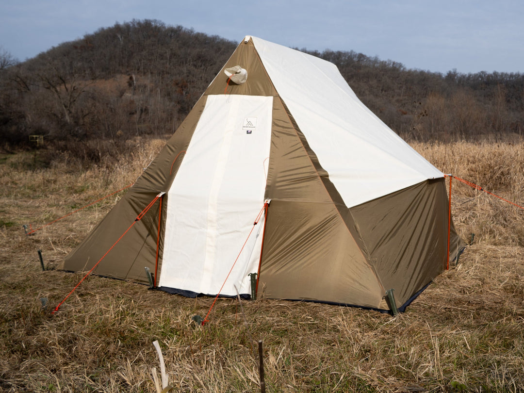Tent set up in a field with a clear sky