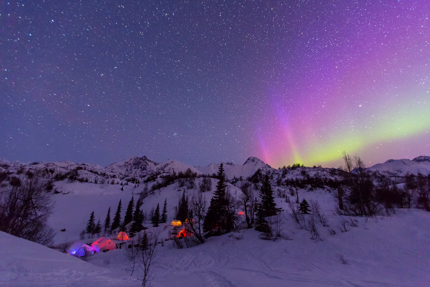 winter night scene with the northern light above mountains and several Snowtrekker Tents