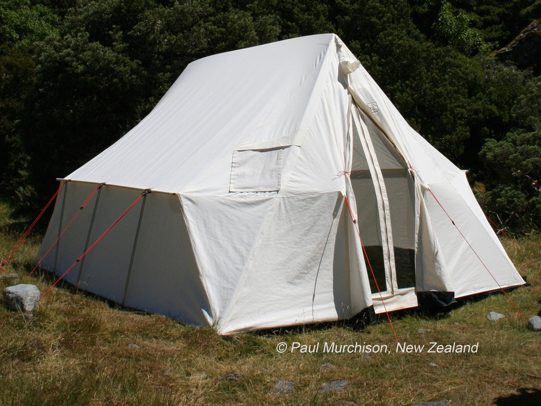 Snowtrekker 10x13 Outfitter Setup In Mountain meadow trees in background in New Zealand